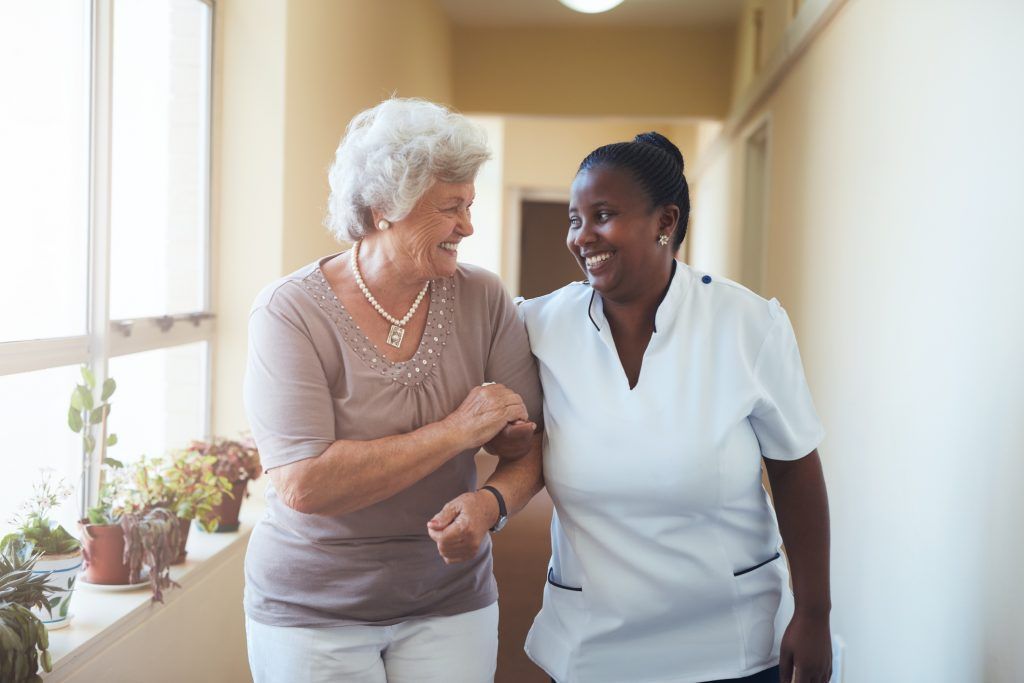 A care worker accompanying an older adult indoors