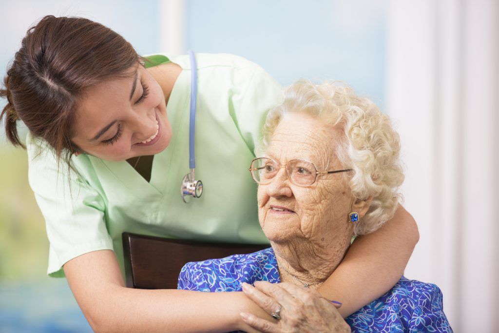 A care worker reassuring an older woman