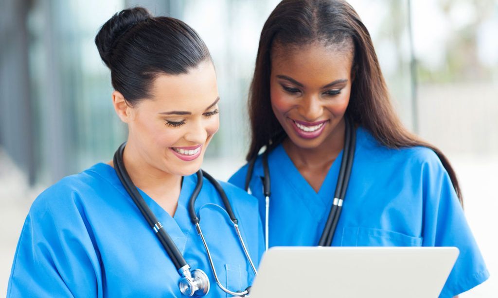 Two healthcare workers reviewing information together