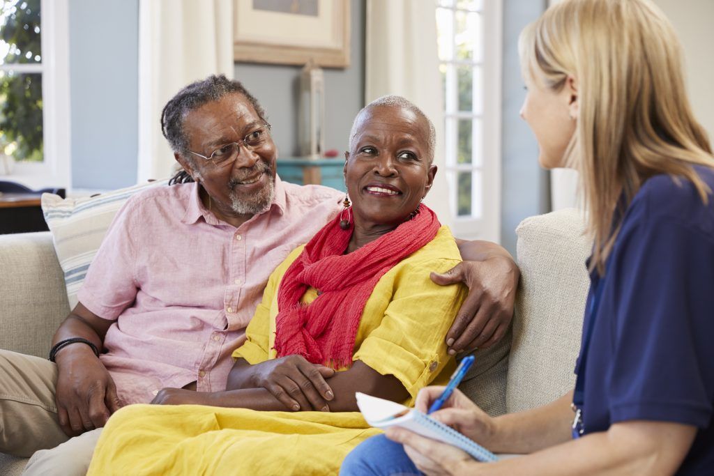 An older couple discussing support with a care professional
